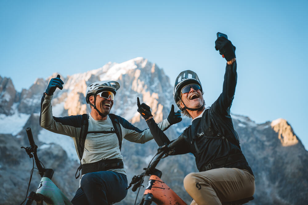 Two riders celebrating at the top of a col on the Tour du Mont Blanc