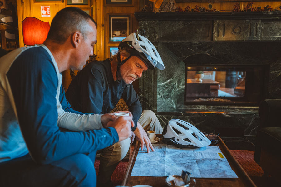 Two riders over an espresso and a map before setting off
