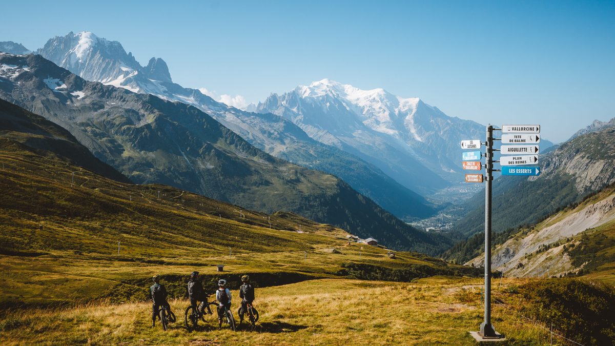 A group of riders at a trail junction with Mont Blanc behind them